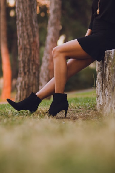 shallow focus photo of person in black booties