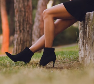 shallow focus photo of person in black booties