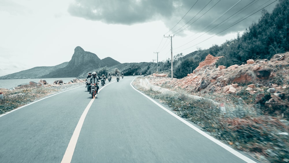 Grupo de personas que conducen motocicleta en la carretera