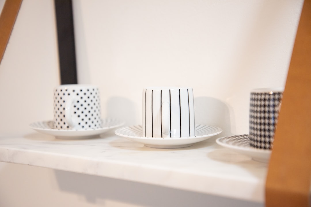 three white-and-black ceramic mugs