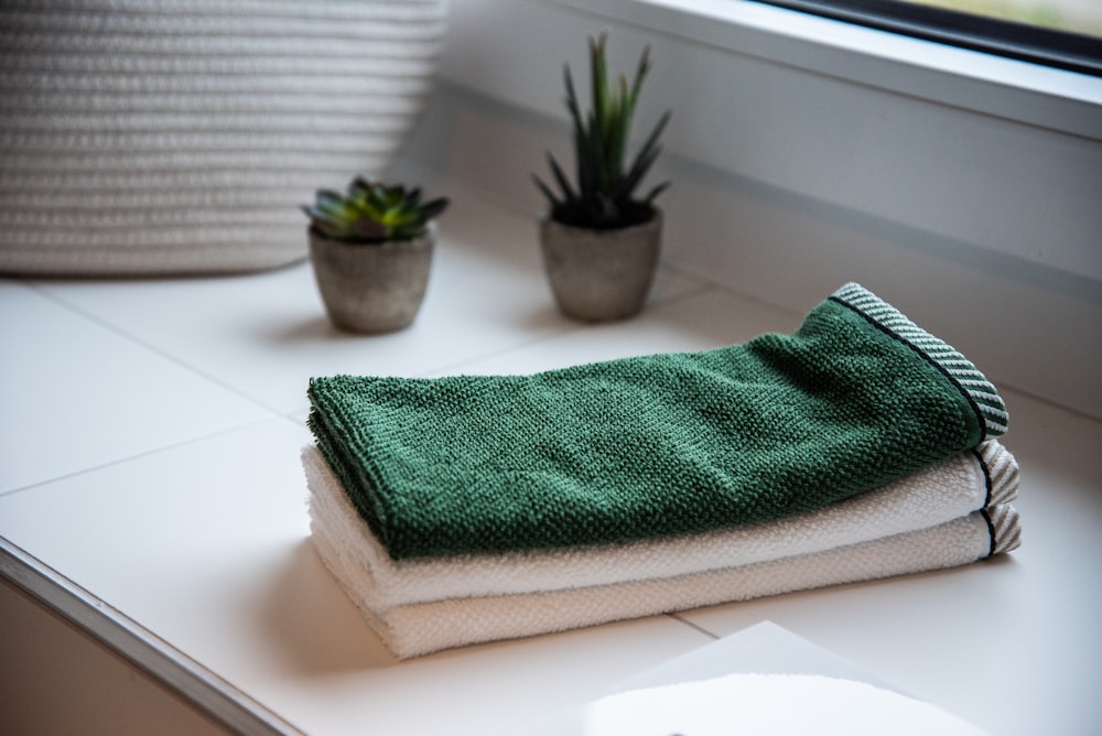 toalhas dobradas perto de vasos de plantas