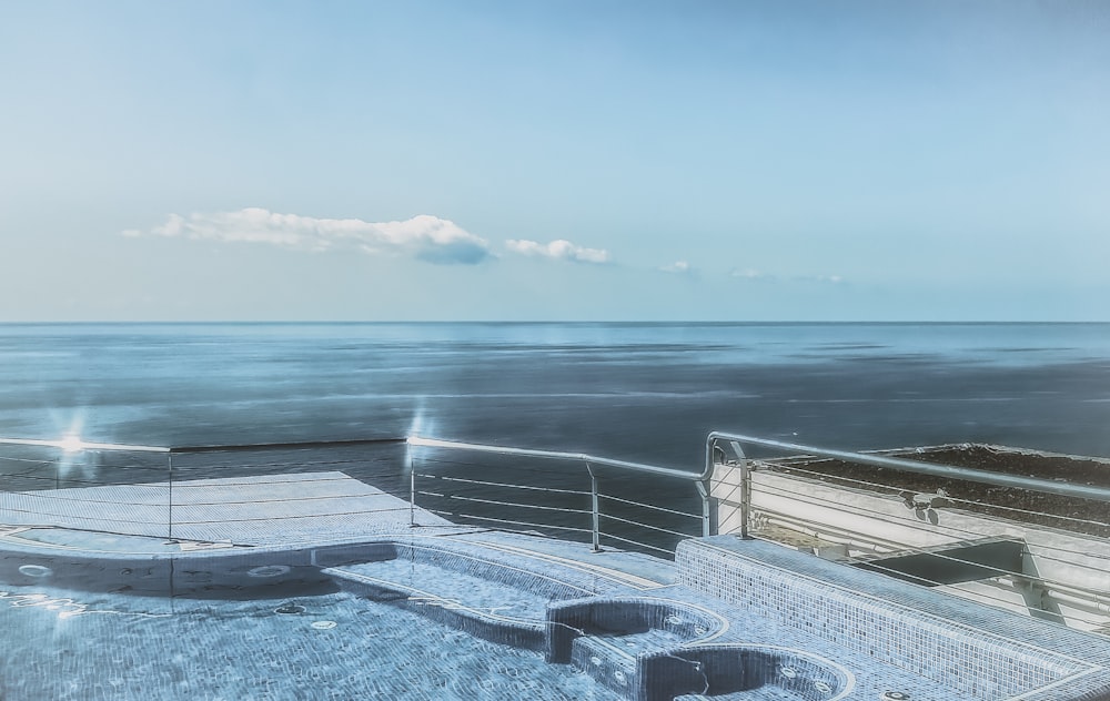 a hot tub sitting on top of a wooden deck next to the ocean