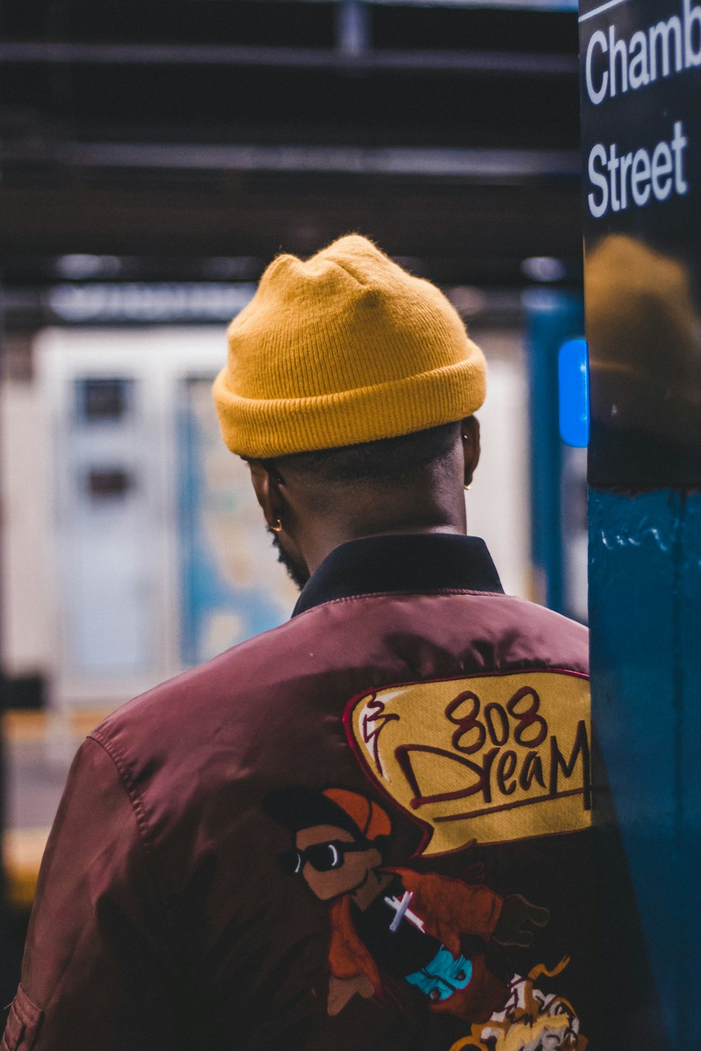 man wearing yellow knit cap and maroon shirt