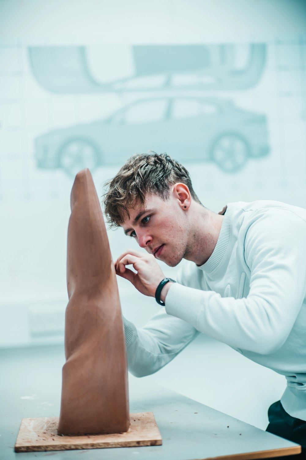 man in white sweater sculpting