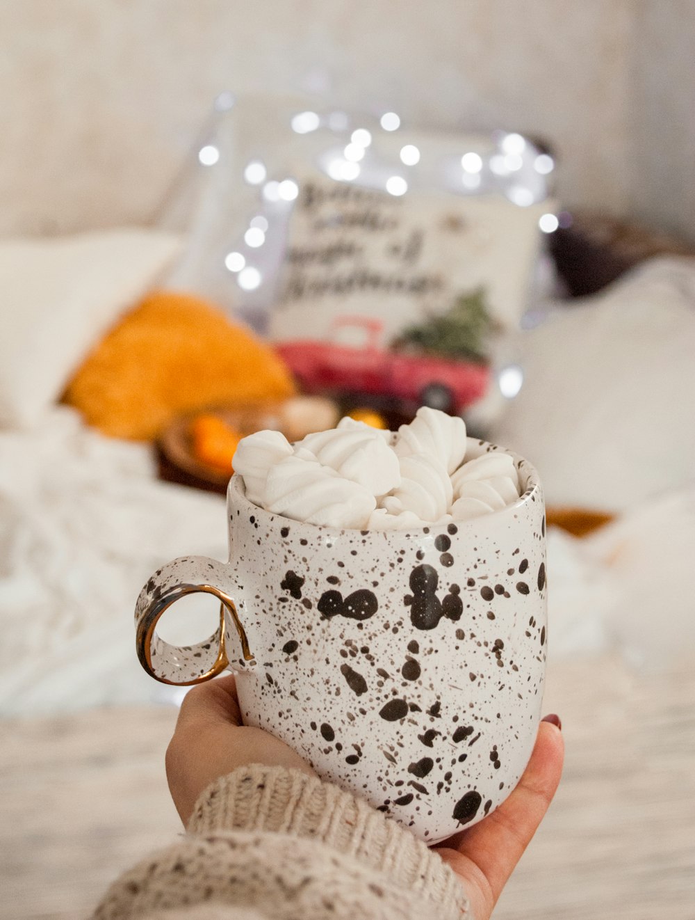 white and black mug on person's hand