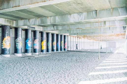 Indoor parkour training area with various bars and obstacles under a roof.