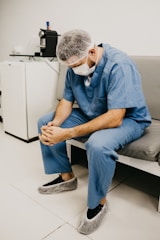 Two nurses in scrubs sharing a quiet moment of reflection in a hospital hallway.