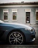 A sleek car parked in front of a vibrant Dakar street market.