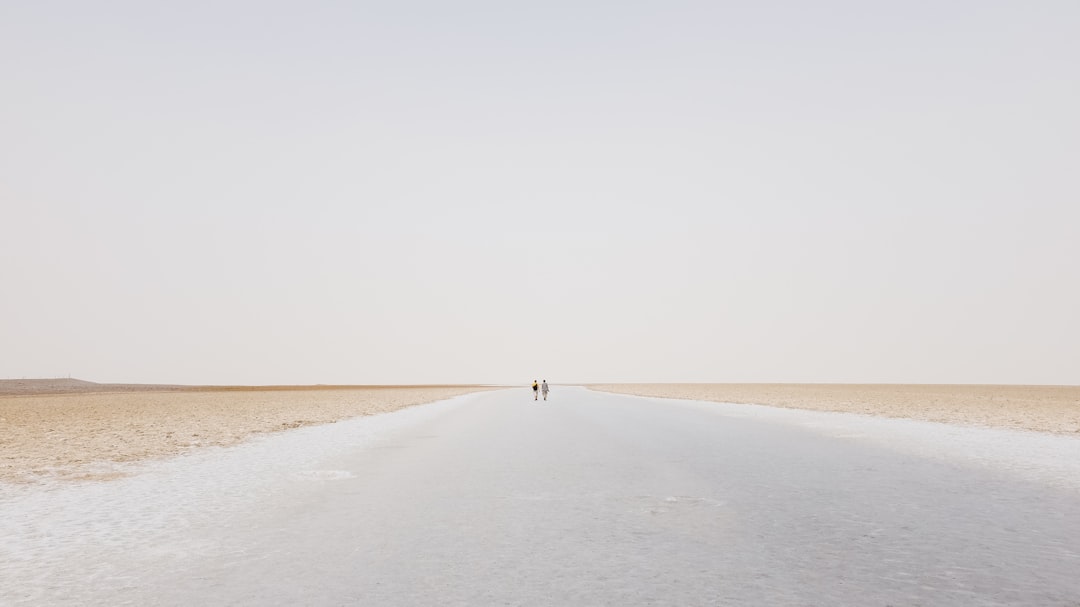 two person walling on desert,