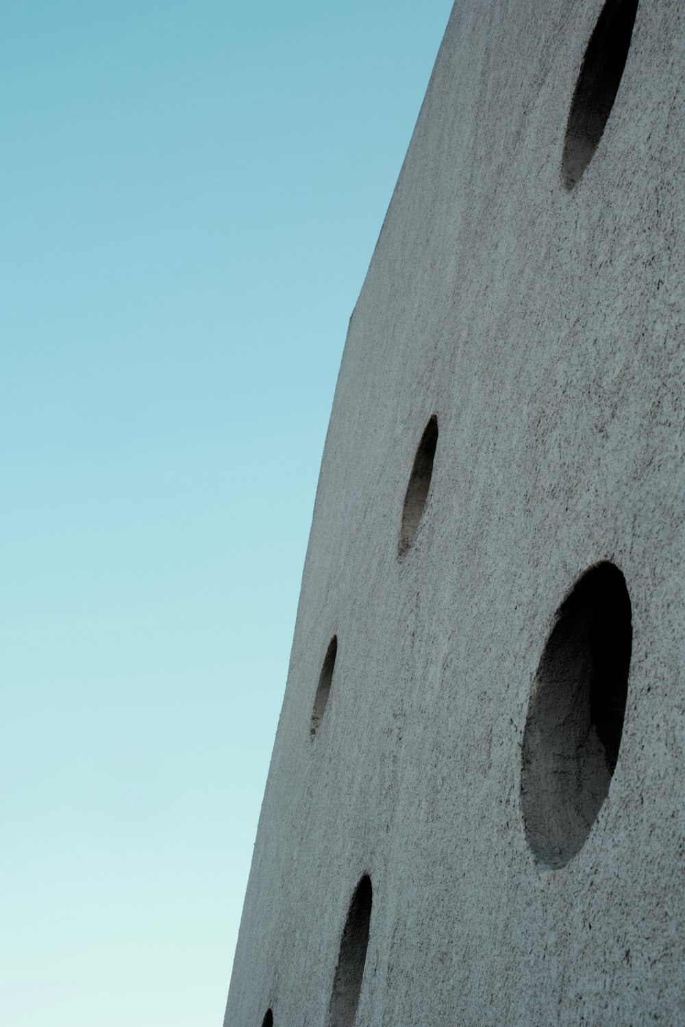 a concrete wall with holes in the middle of it