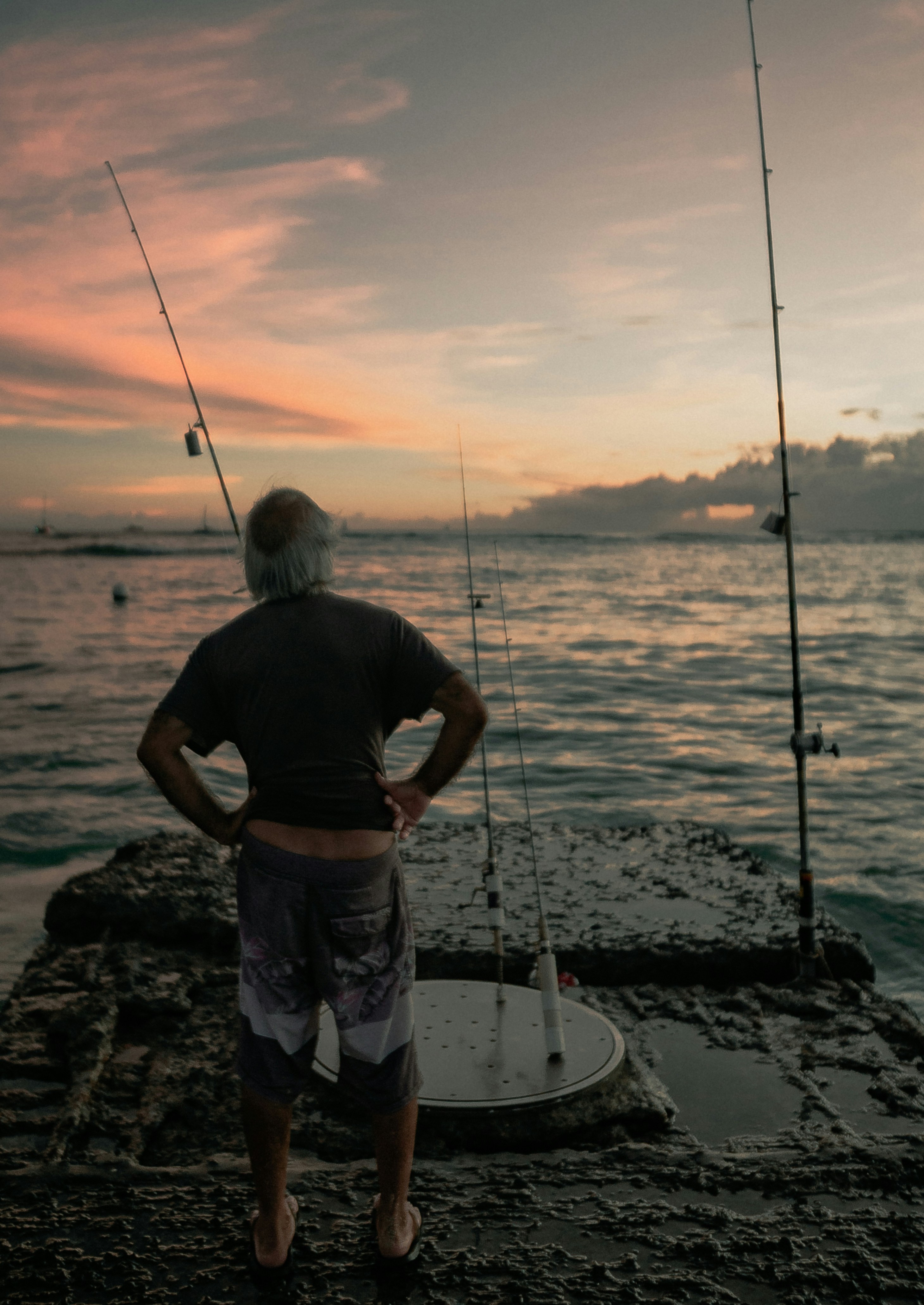 男は釣り竿の近くに立ち 魚が釣れるのを待っているの写真 Unsplashで見つけるワイキキの無料写真