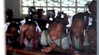 selective focus photo of children leaning on deks