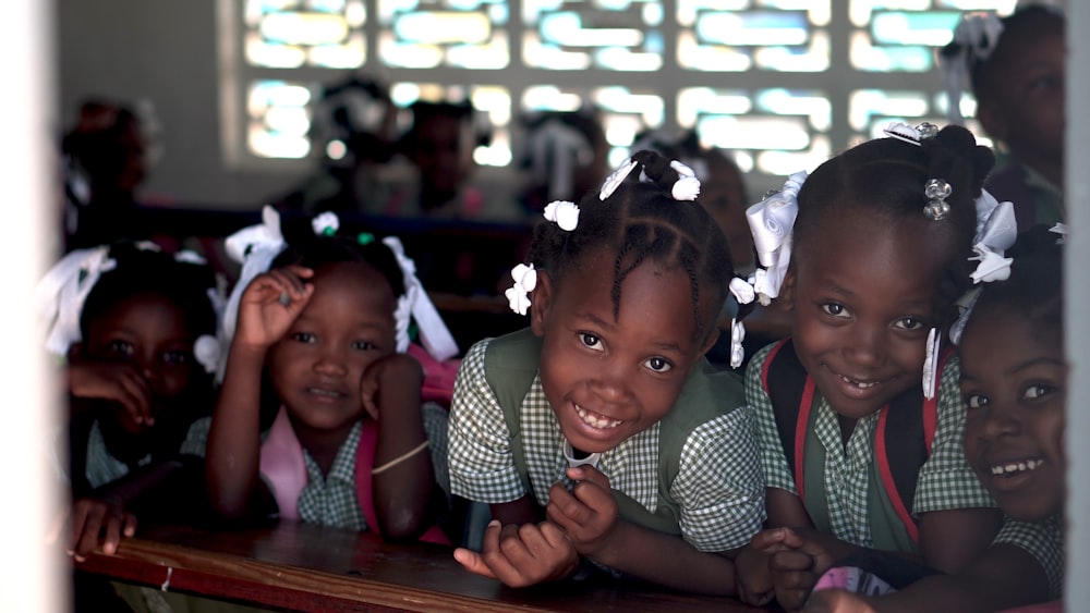 selective focus photo of children leaning on deks