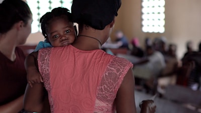 A volunteer comforting a child in an orphanage setting.