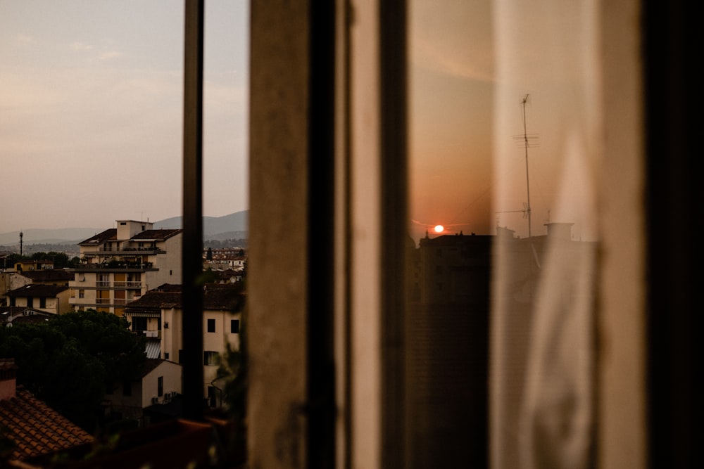 a window with a view of a city at sunset