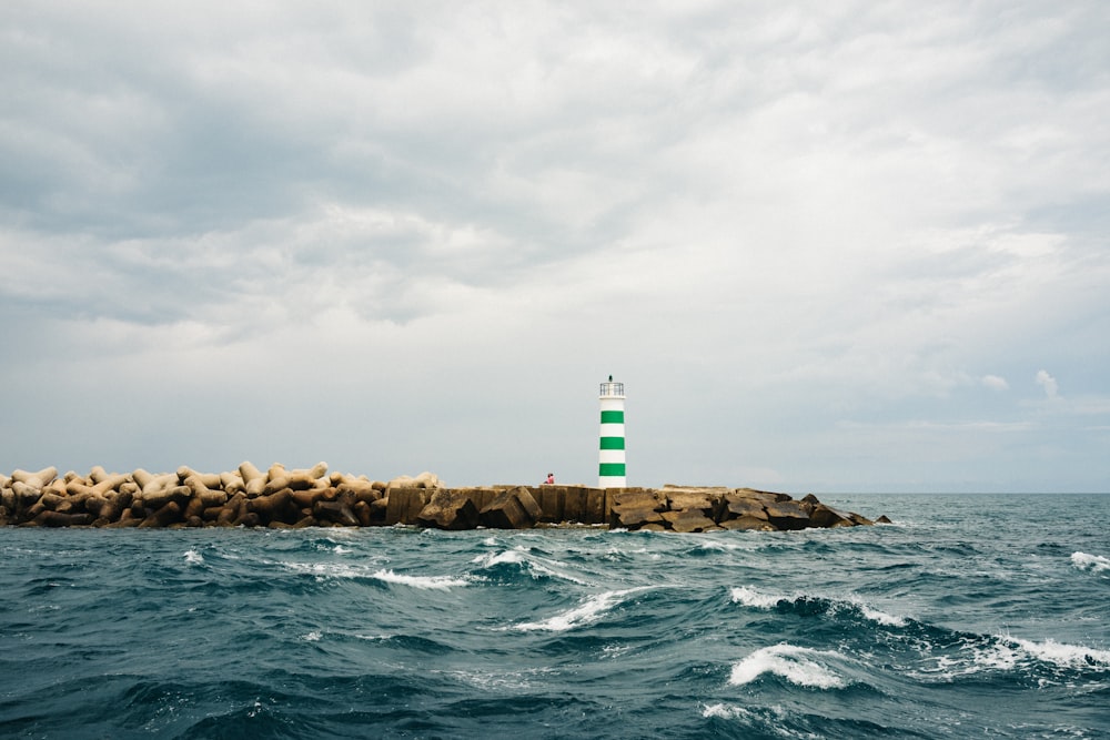 Faro junto al océano ondulado durante el día