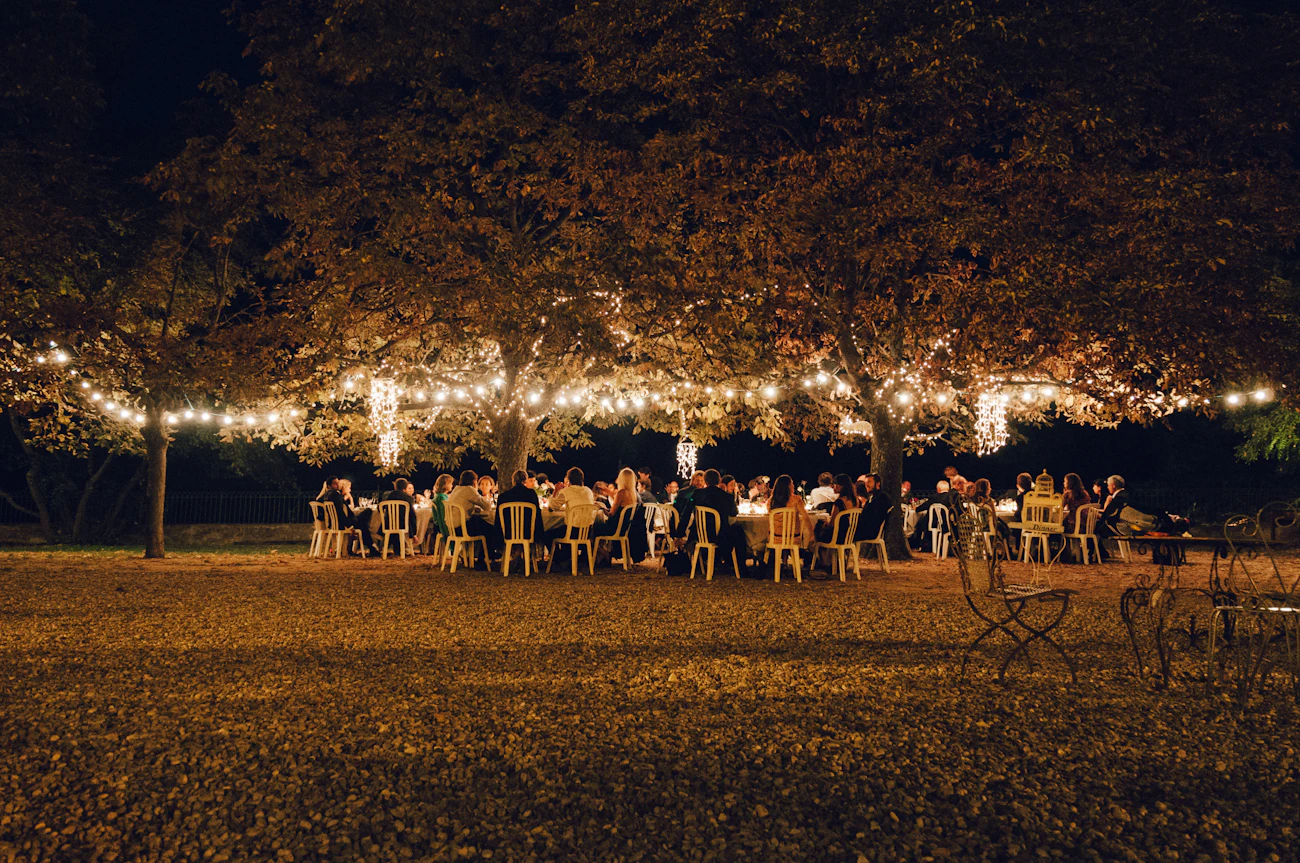 Guests gathered beneath string lights at an elegant outdoor reception