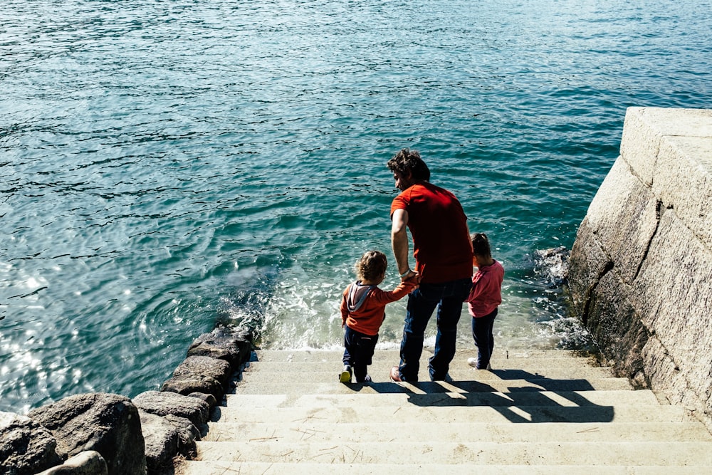 Un hombre y dos niños subiendo un tramo de escaleras