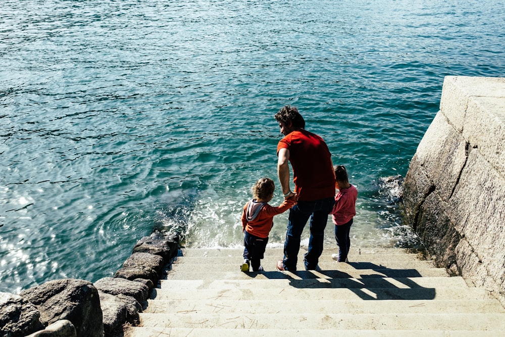 a man and two children walking up a flight of stairs