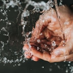 a person holding their hands under a stream of water