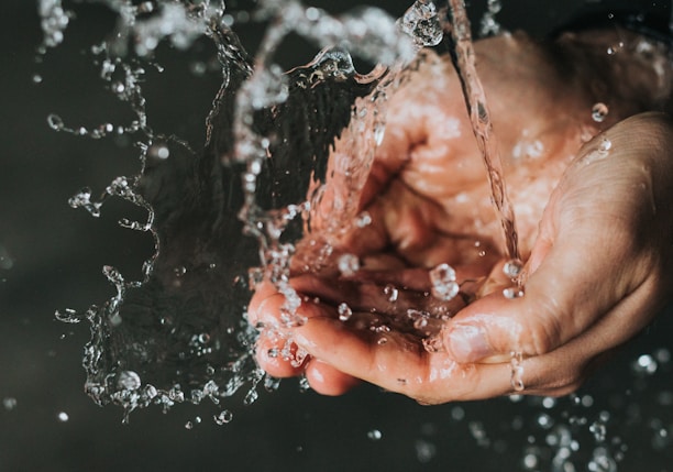 a person holding their hands under a stream of water