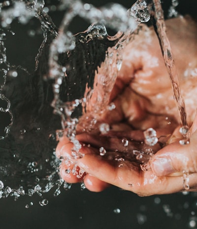 a person holding their hands under a stream of water