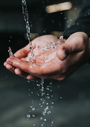 clear liquid pouring on person's hands