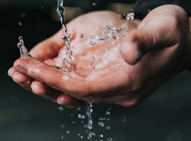 clear liquid pouring on person's hands