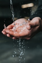 clear liquid pouring on person's hands