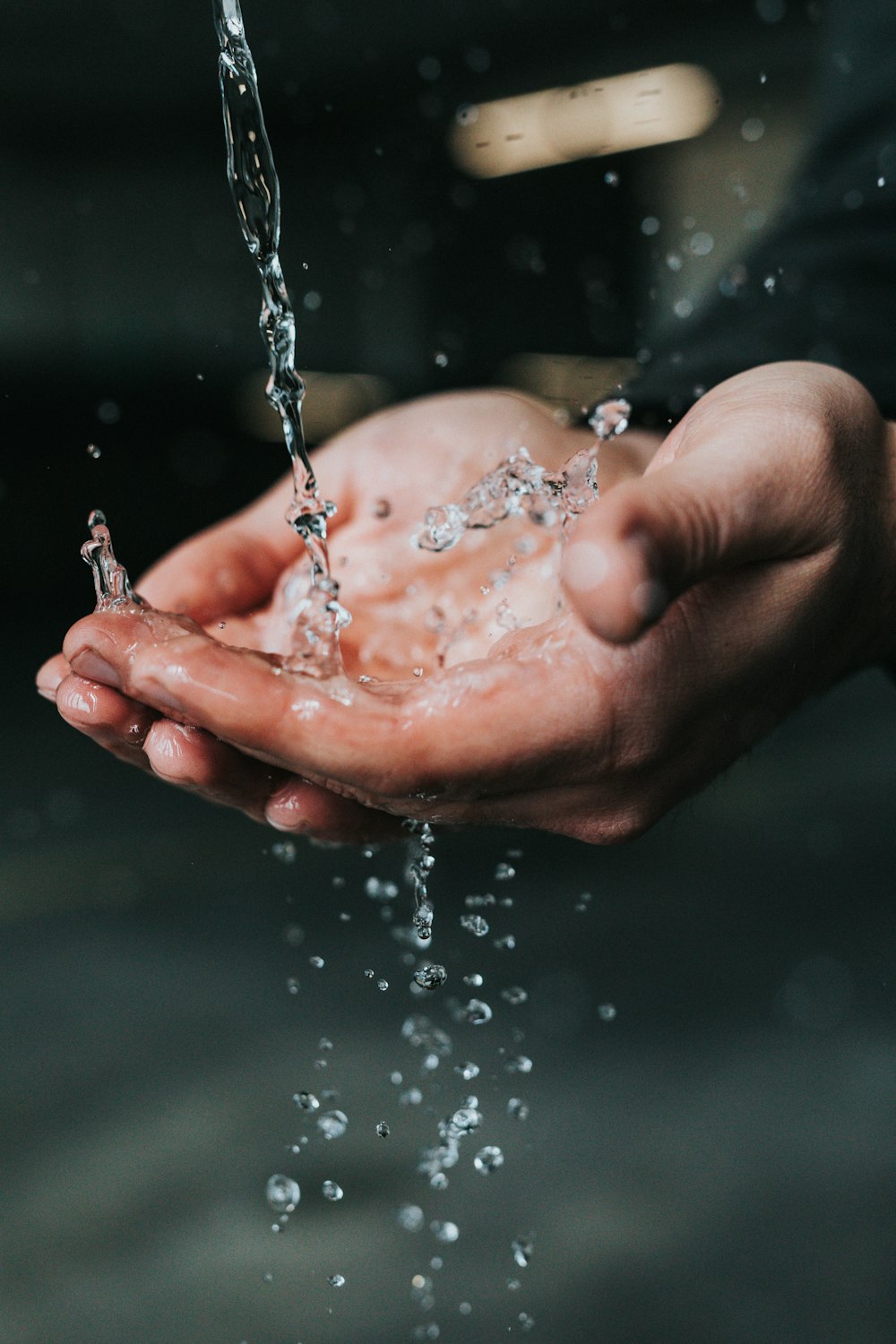 clear liquid pouring on person's hands