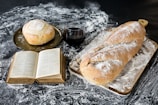A cozy kitchen scene with a vintage cookbook open next to freshly baked bread.