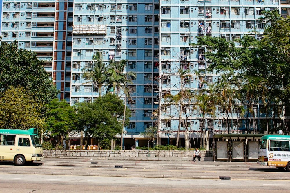 Furgoneta blanca y azul en la carretera cerca de un edificio de gran altura