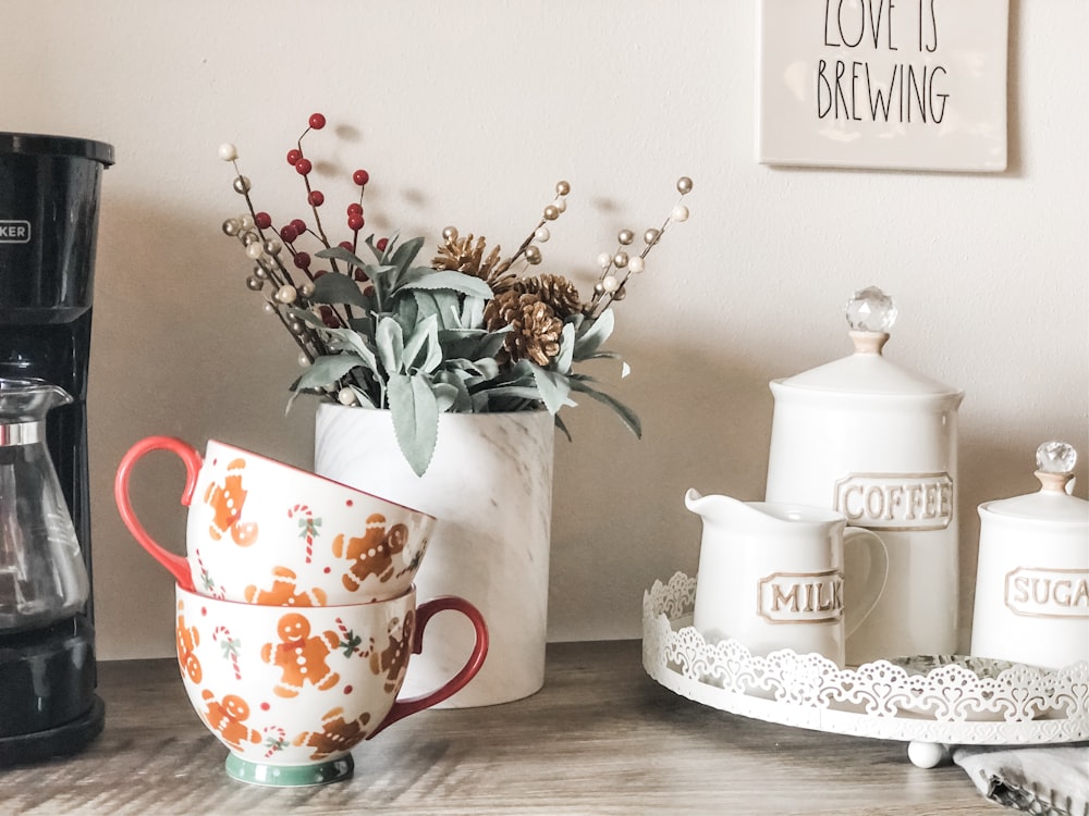 orangefarbene und weiße Teetassen aus Keramik mit Blumenmuster