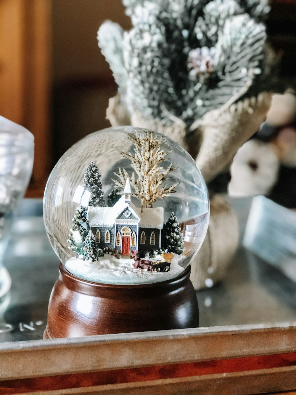 blue and red house near trees snowglobe