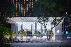 A factory surrounded by green trees symbolizing reduced environmental impact.