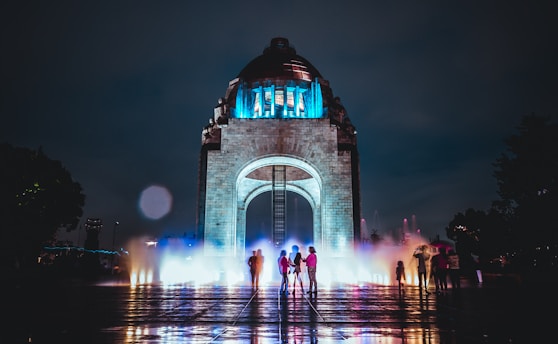 five person standing behind arch tower