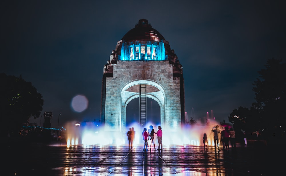 five person standing behind arch tower