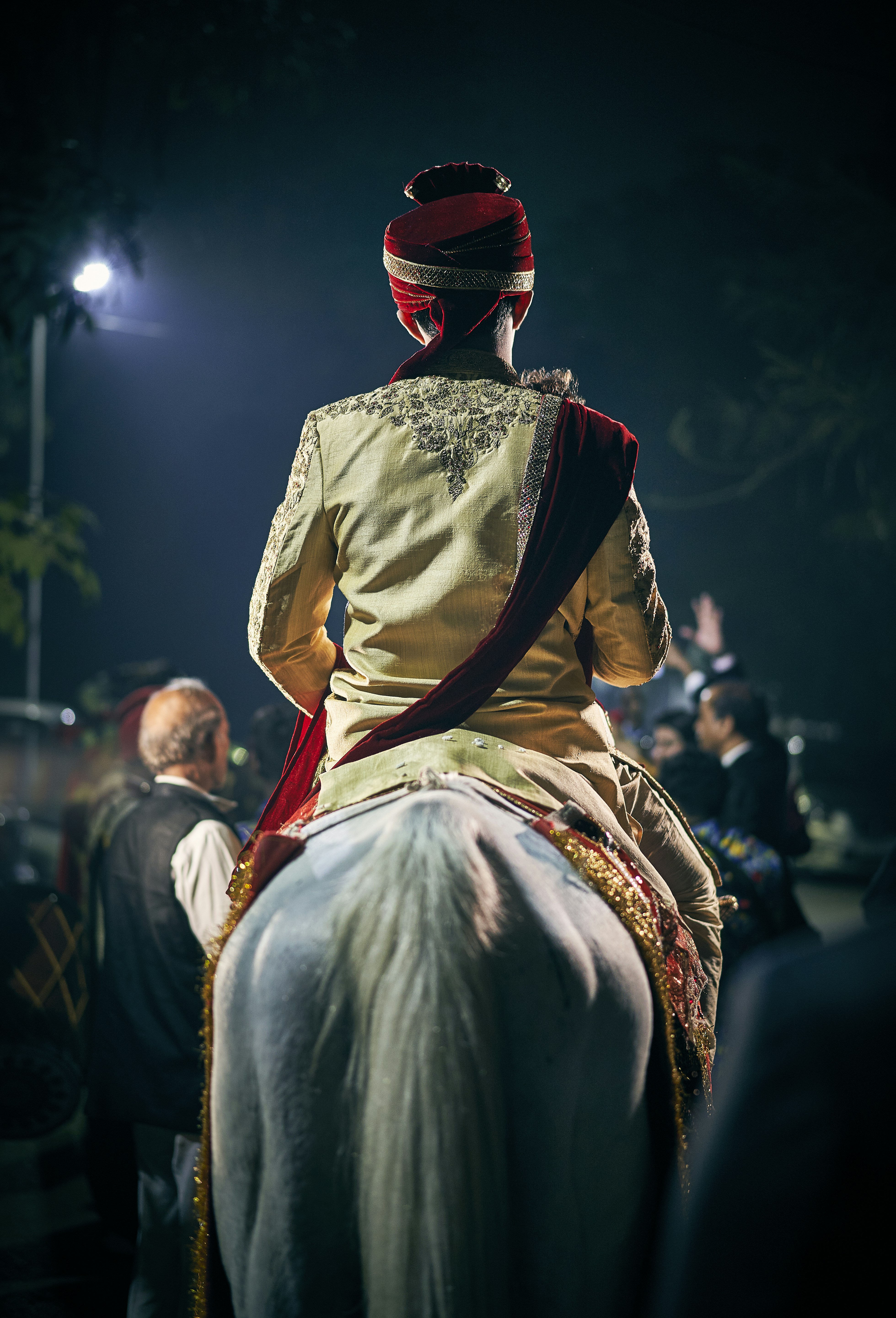 person sitting on horse near people during night
