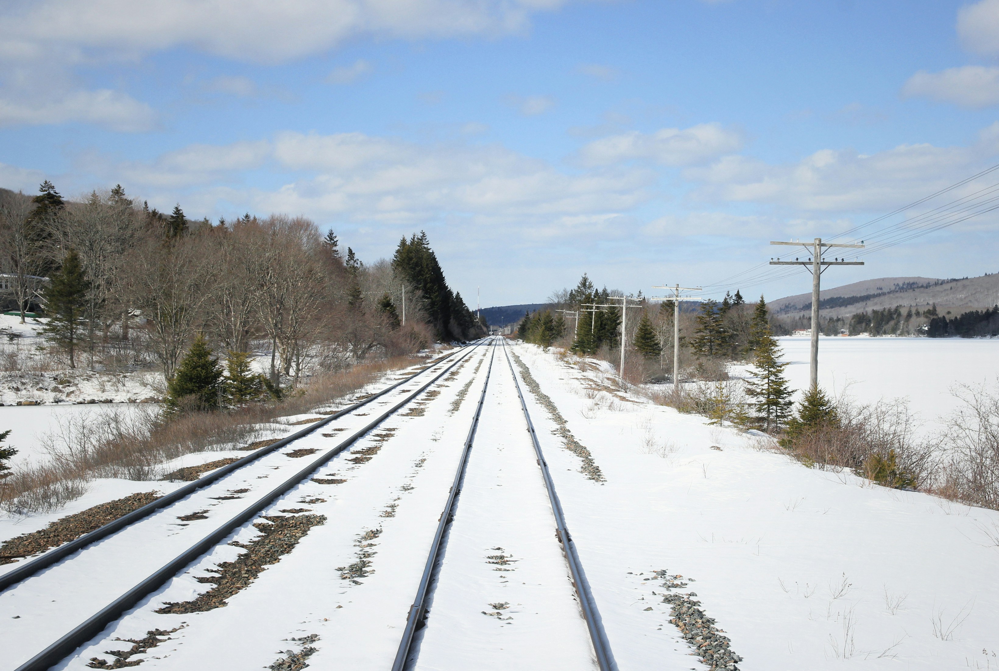 railway covered with snow under cloudy sky, Alors que le train s’arrête au milieu de la voie, certains infinis s’ouvrent à l’horizon.