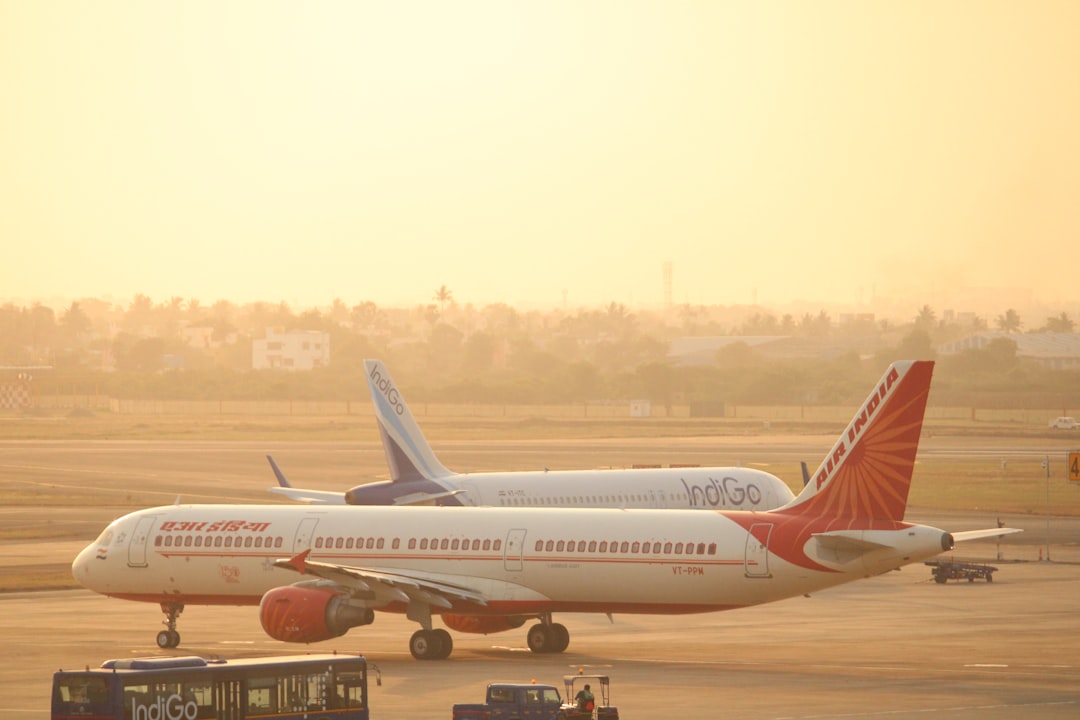 black bus beside white and red plane,