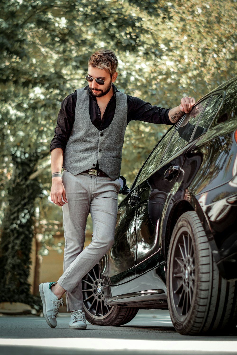 man standing beside car