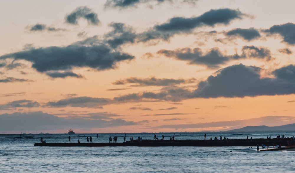 people walking and standing on seawall