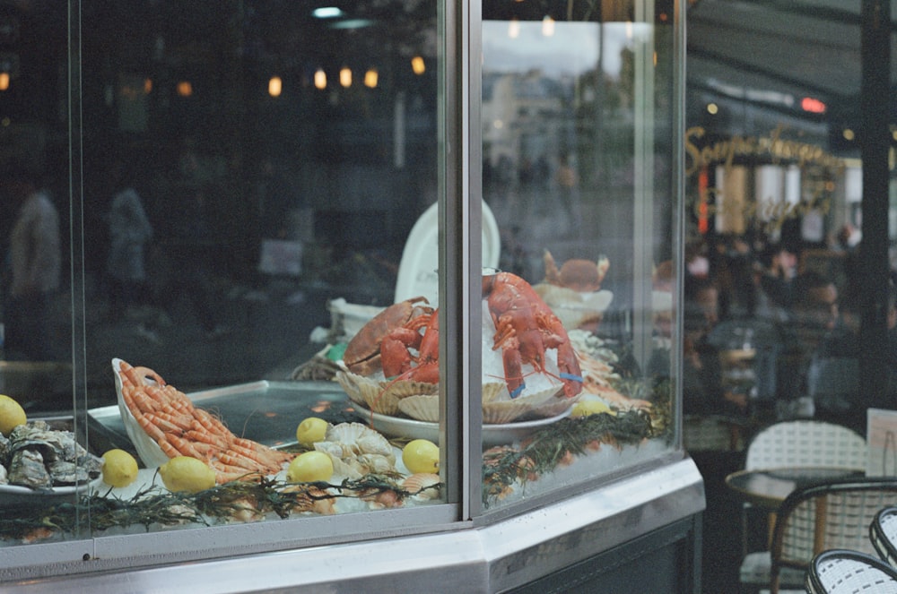 a display case with lobsters and other seafood in it