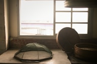 Natural light illuminating a collection of bamboo woven products arranged with dried flowers and linen fabric.