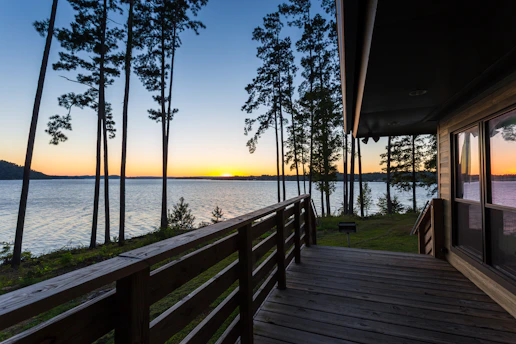 Sunset over a spacious rooftop deck overlooking a sparkling lake and rolling hills.