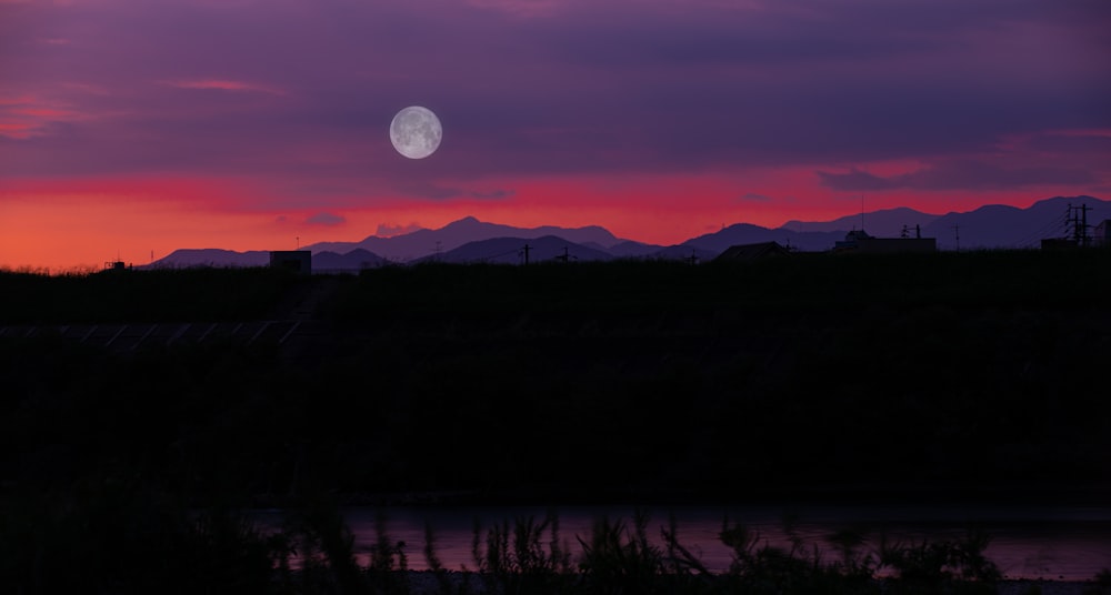 the sun is setting over a mountain range