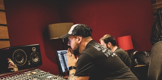 Creative team collaborating intensely around high-tech digital workstations in a modern studio environment.