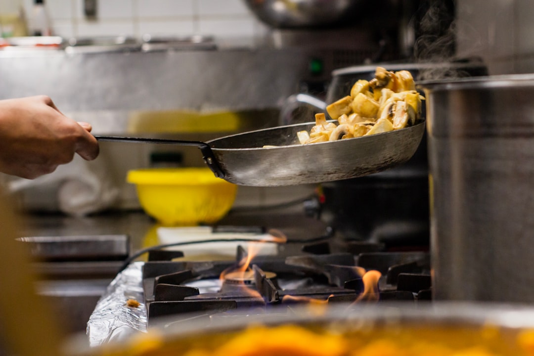 person cooking food on pan