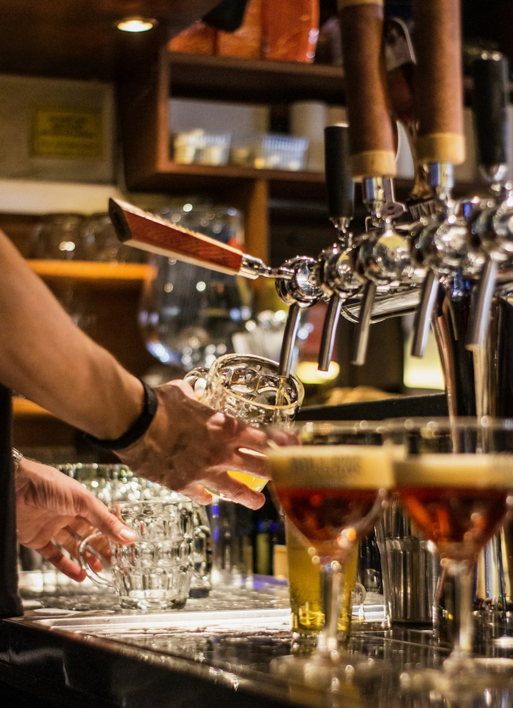 Um barman derrama um copo de cerveja em um bar