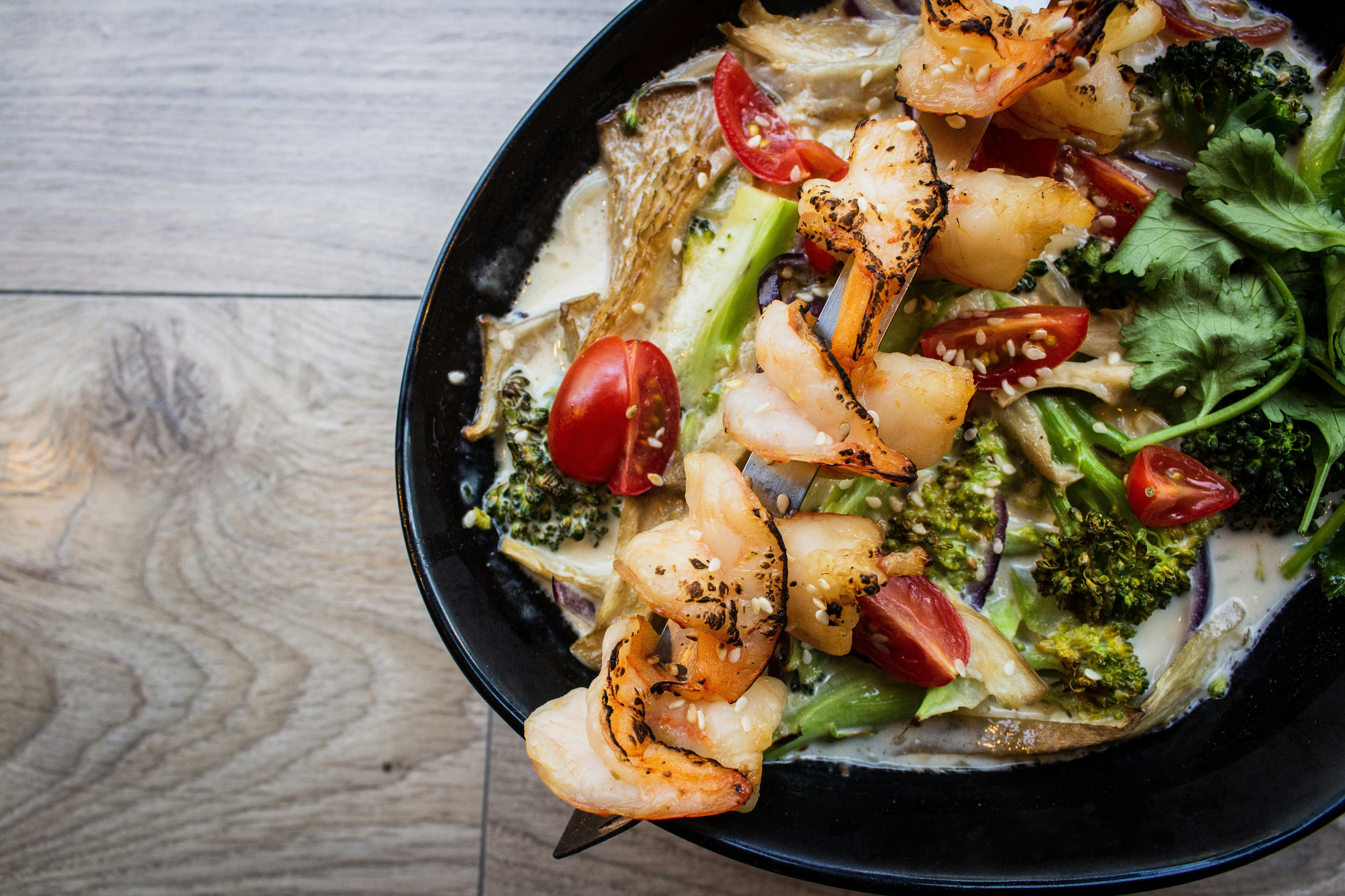 bowl of food on gray wooden surfaceby Louis Hansel